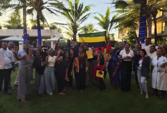 Les élèves et les accompagnatrices avec le personnel de l'hôtel et le drapeau Mauricien