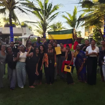 Les élèves et les accompagnatrices avec le personnel de l'hôtel et le drapeau Mauricien